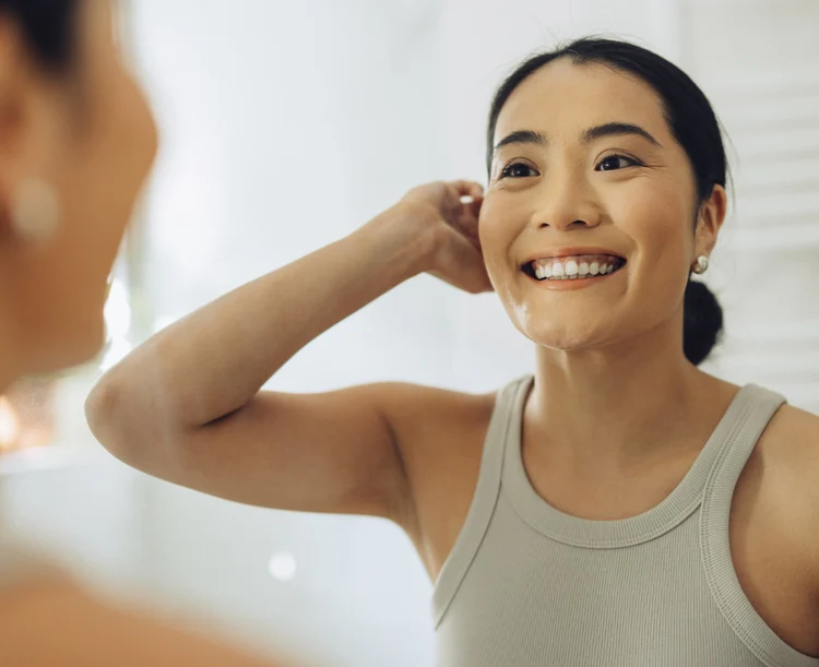 Women in grey t-shirt smiling after using Pro Fresh mouthwash