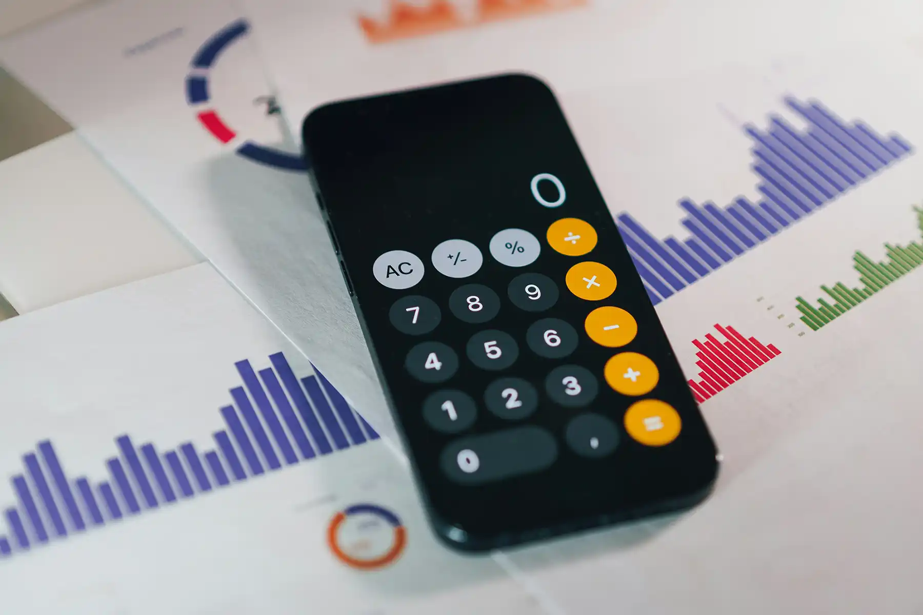 Desk with calculator and marketing sheets with analytics